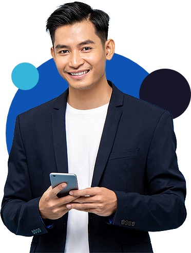 Un homme asiatique souriant, vêtu d'une veste bleue foncée, tenant un smartphone argenté.